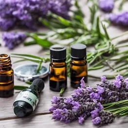 A close-up photograph of a variety of aromatic essential oils, such as lavender, bergamot, and rosemary, alongside a blood glucose monitoring device and a notebook filled with data, symbolizing the potential impact of aromatherapy on blood sugar stability.
